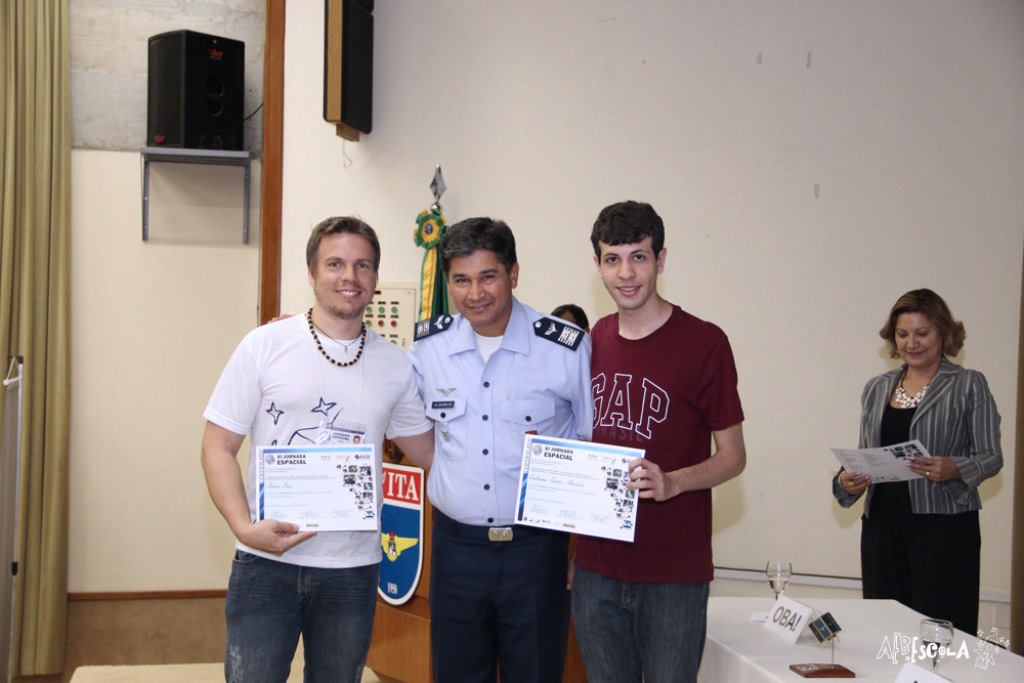 Oficial da Aeronáutica entrega os certificados de participação na XI Jornada Espacial para o professor de Física Andrei Buse (à esquerda) e para o estudante Guilherme Santos Machado, ambos do Bom Jesus Santo Antônio.